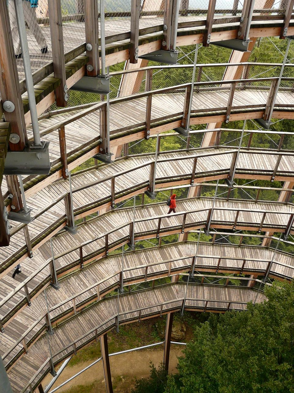 Stack of books and laptop on wooden desk, symbolizing knowledge and resources